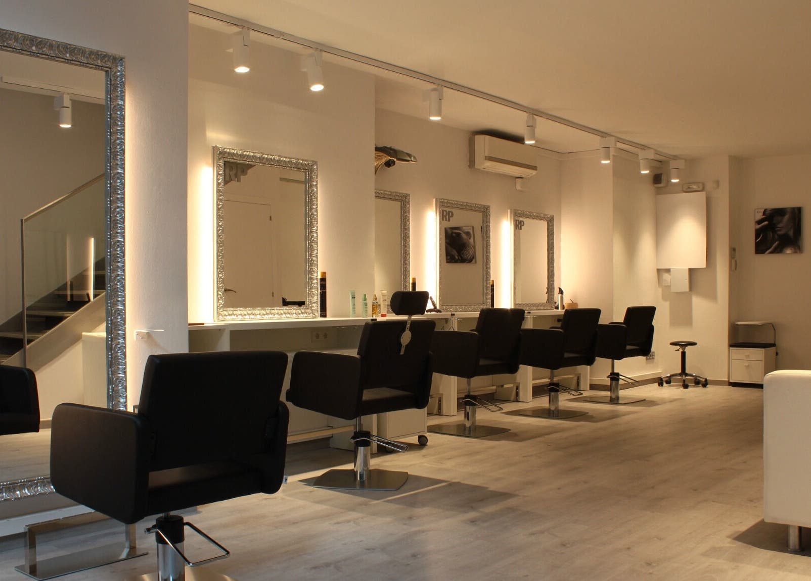 Interior moderno de Raffel Pages Provença en Barcelona, Catalunya, ES con espejos iluminados y sillas estilistas.