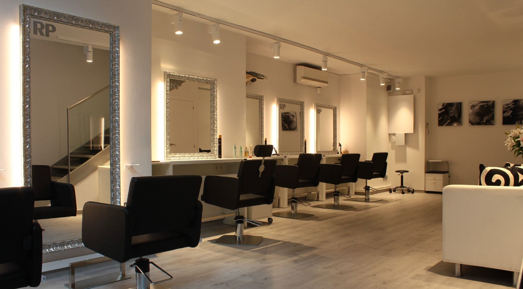 Interior moderno de Raffel Pages Provença en Barcelona, Catalunya, ES con espejos iluminados y sillas estilistas.