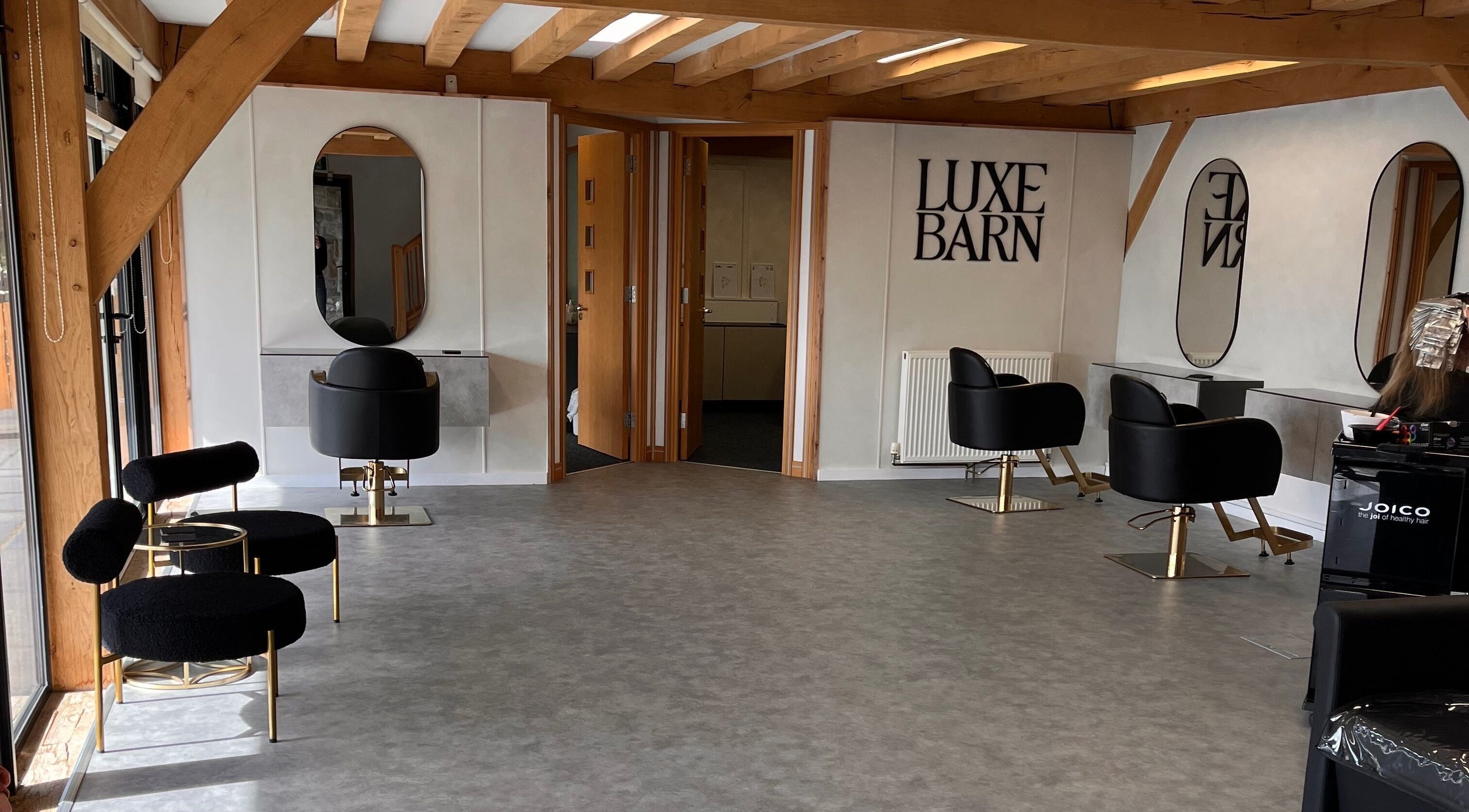 Chic and modern salon interior at AlexandraJaine Extensions, Tickenham, England, GB. Stylish seating and mirrors.