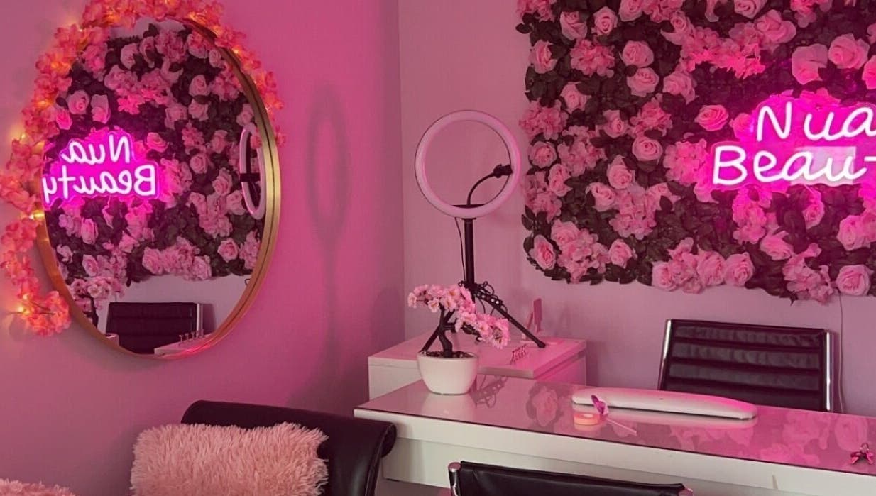 Nuabeauty interior with pink rose decor and neon sign in Bradford, England, GB.