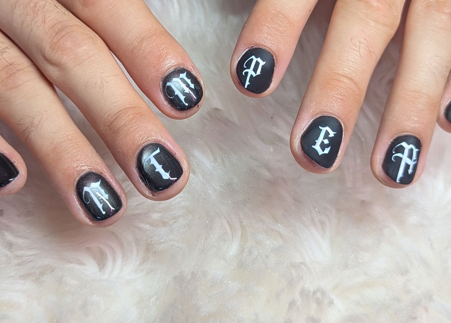 Manucure gothique noire avec lettres blanches à Coquette minute, Montpellier, Occitanie, FR.