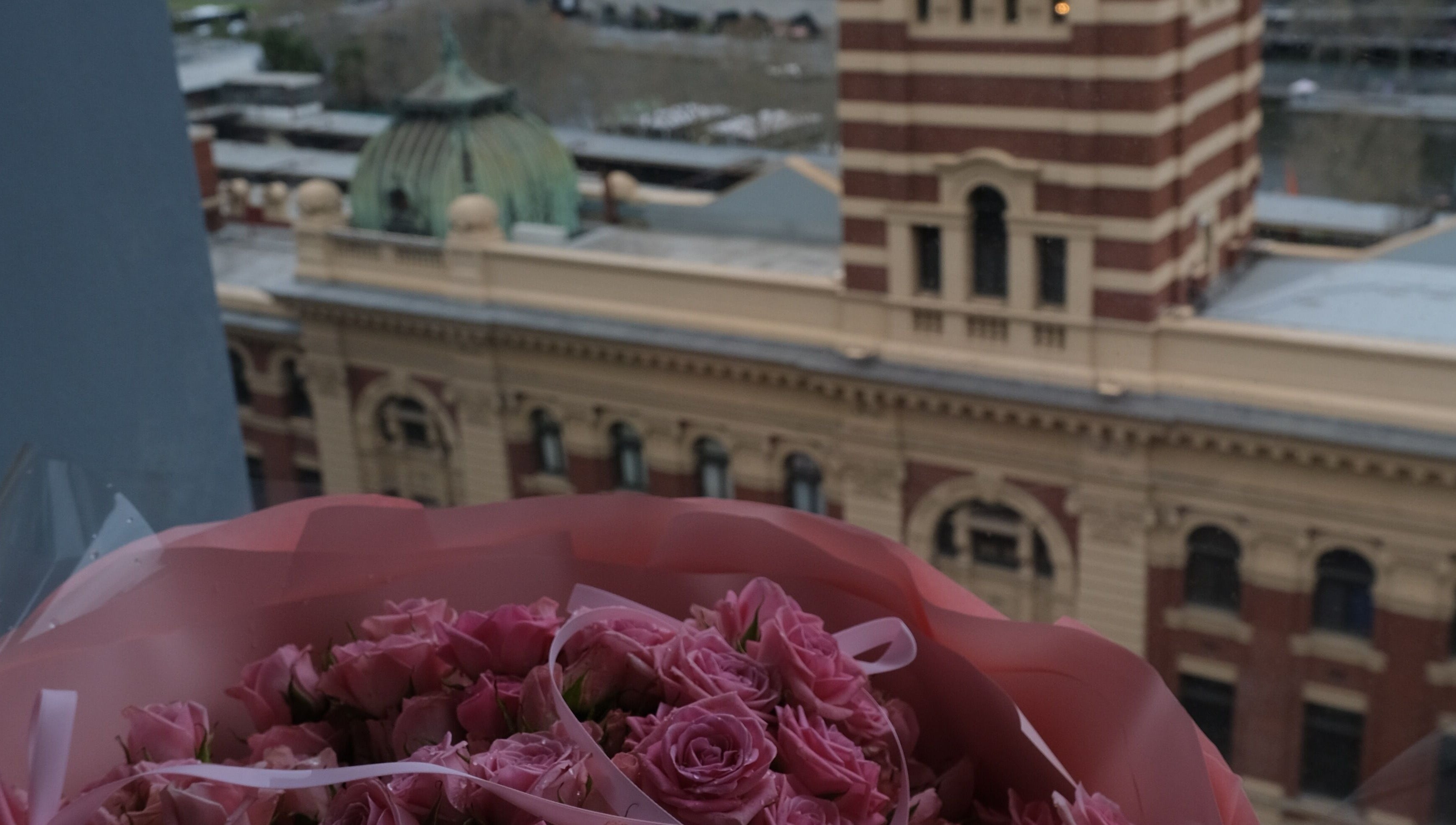 Bouquet of pink roses with view of historic building near LashMap Beauty Studio, Melbourne, AU.