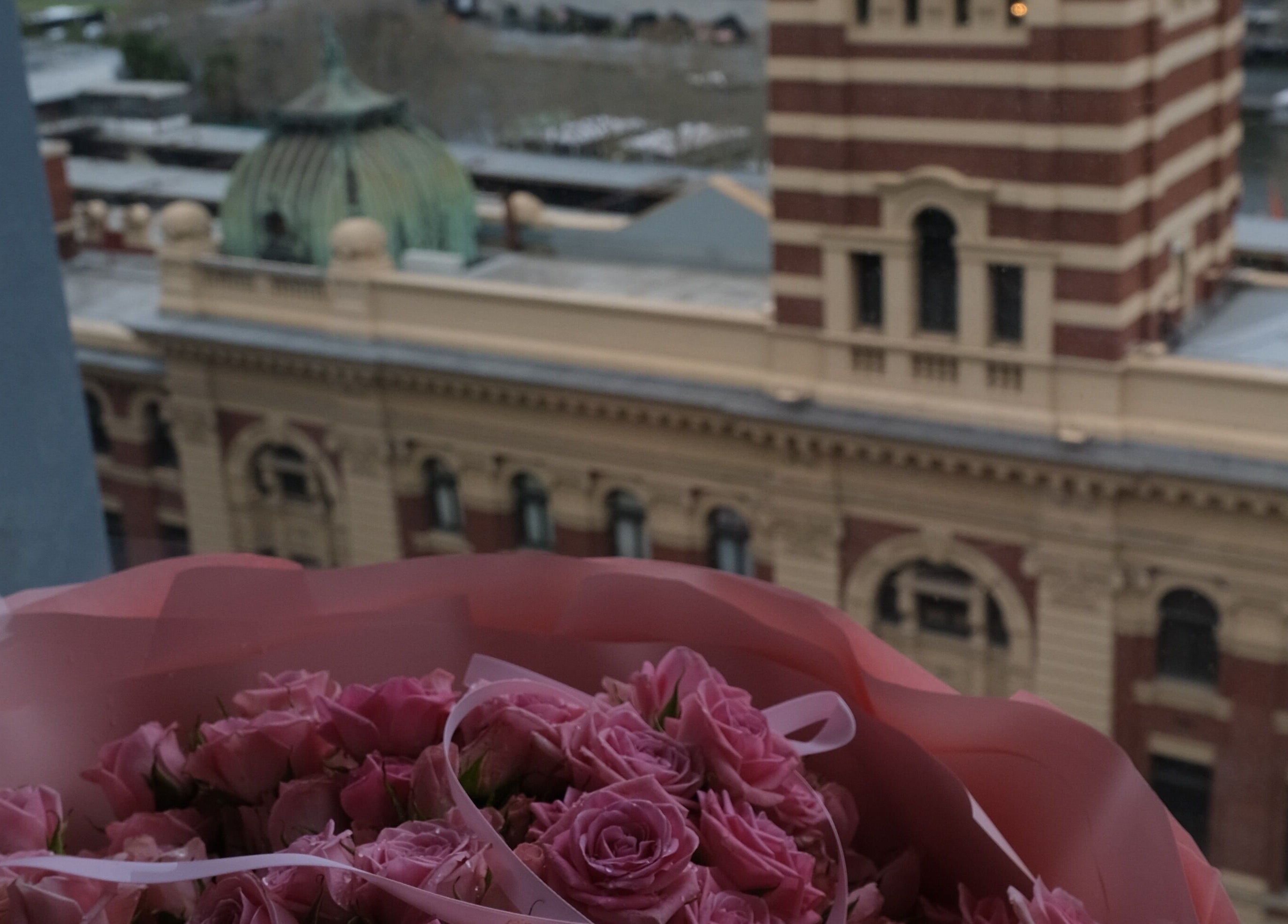 Bouquet of pink roses with view of historic building near LashMap Beauty Studio, Melbourne, AU.