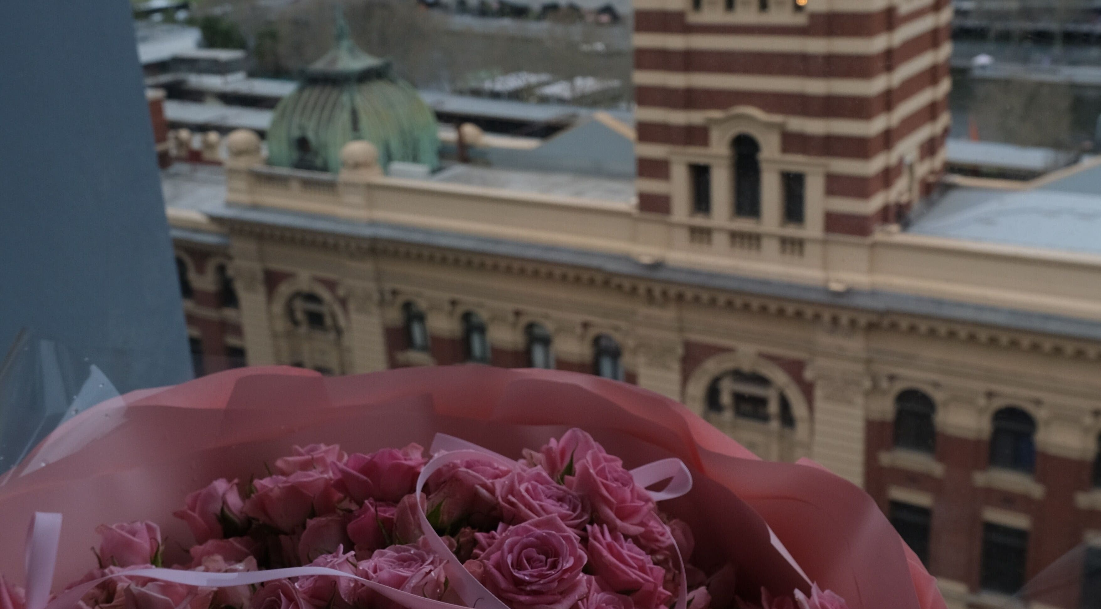 Bouquet of pink roses with view of historic building near LashMap Beauty Studio, Melbourne, AU.