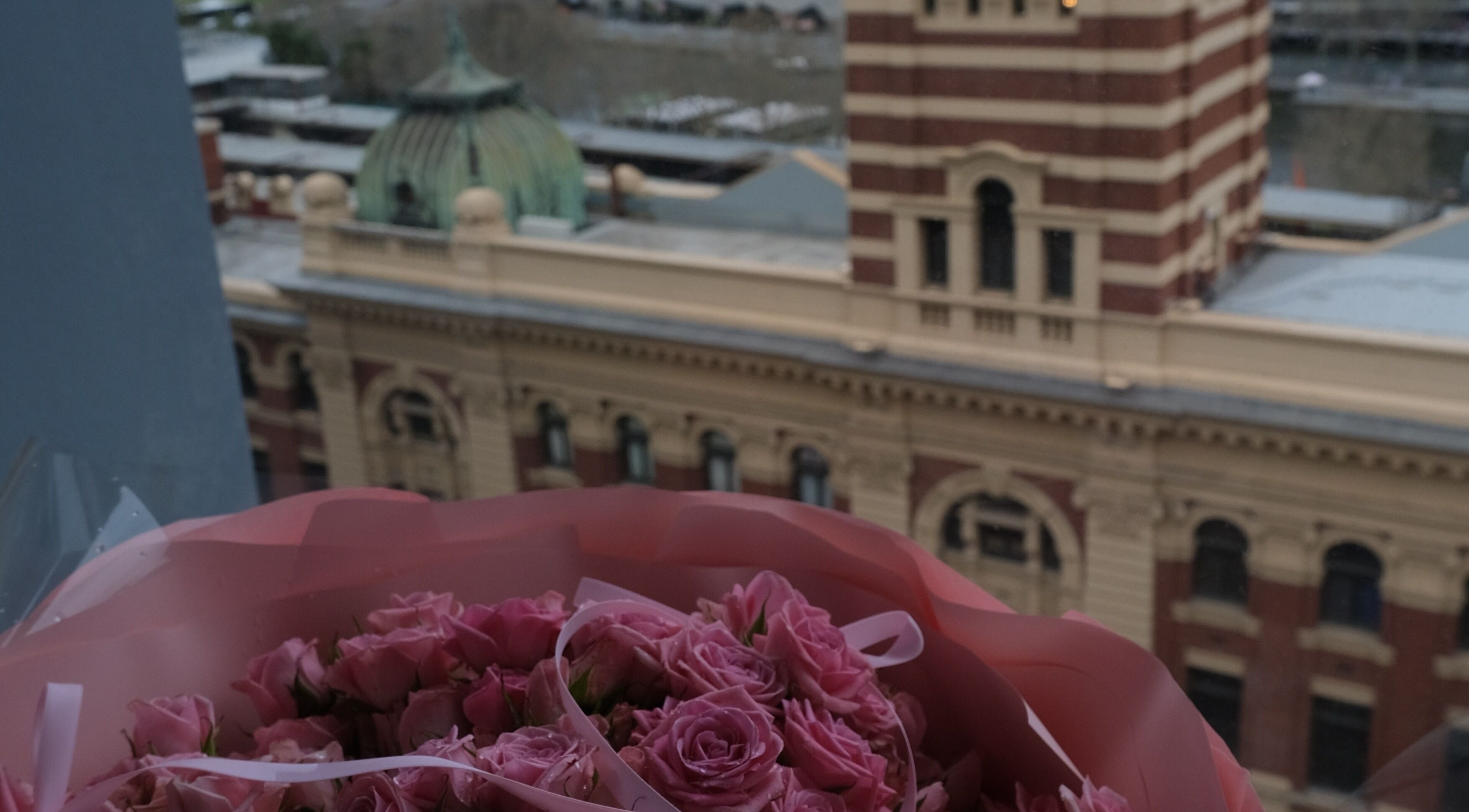 Bouquet of pink roses with view of historic building near LashMap Beauty Studio, Melbourne, AU.