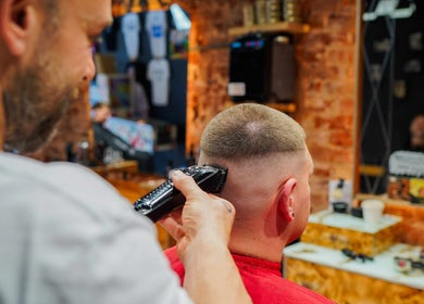 Barber expertly trims hair at Robbie's Chop Shop, Adelaide, South Australia, AU, showcasing skilled grooming.