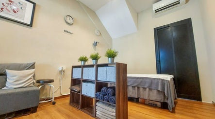 Relaxing massage room at Zensational Sports Massage Therapy in Singapore, SG, with plants and cozy decor.