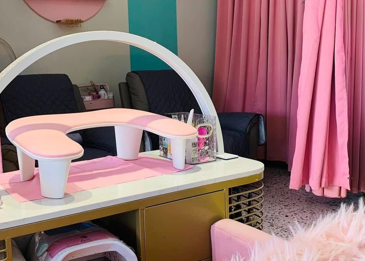Chic nail station at All Glammed Up in Cebu City, Central Visayas, PH, featuring pink decor and plush seating.