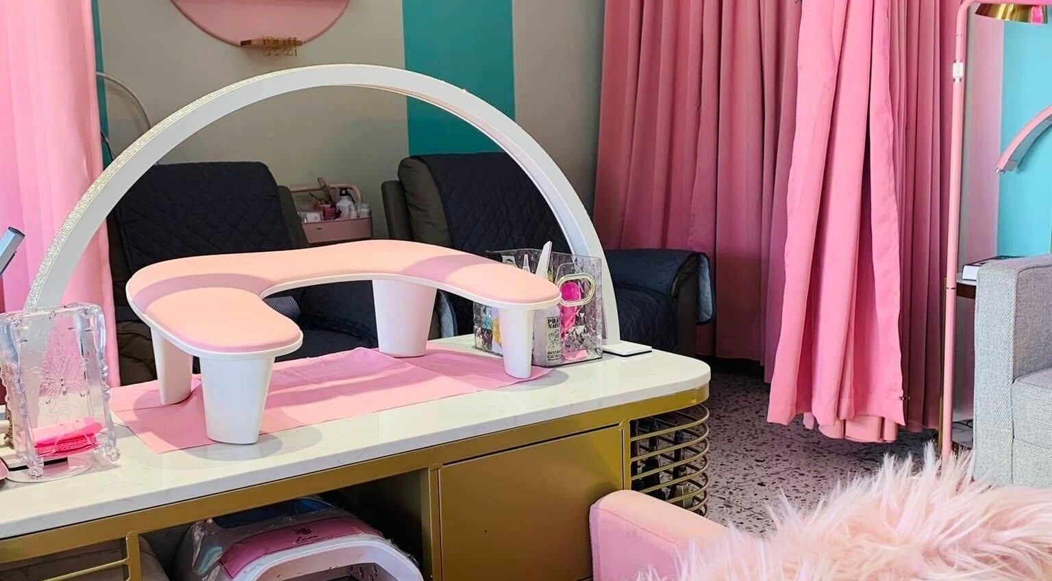Chic nail station at All Glammed Up in Cebu City, Central Visayas, PH, featuring pink decor and plush seating.
