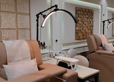 Relaxing spa lounge at Lish Hair & Beauty - JBR in Dubai, AE with plush chairs and modern lighting.