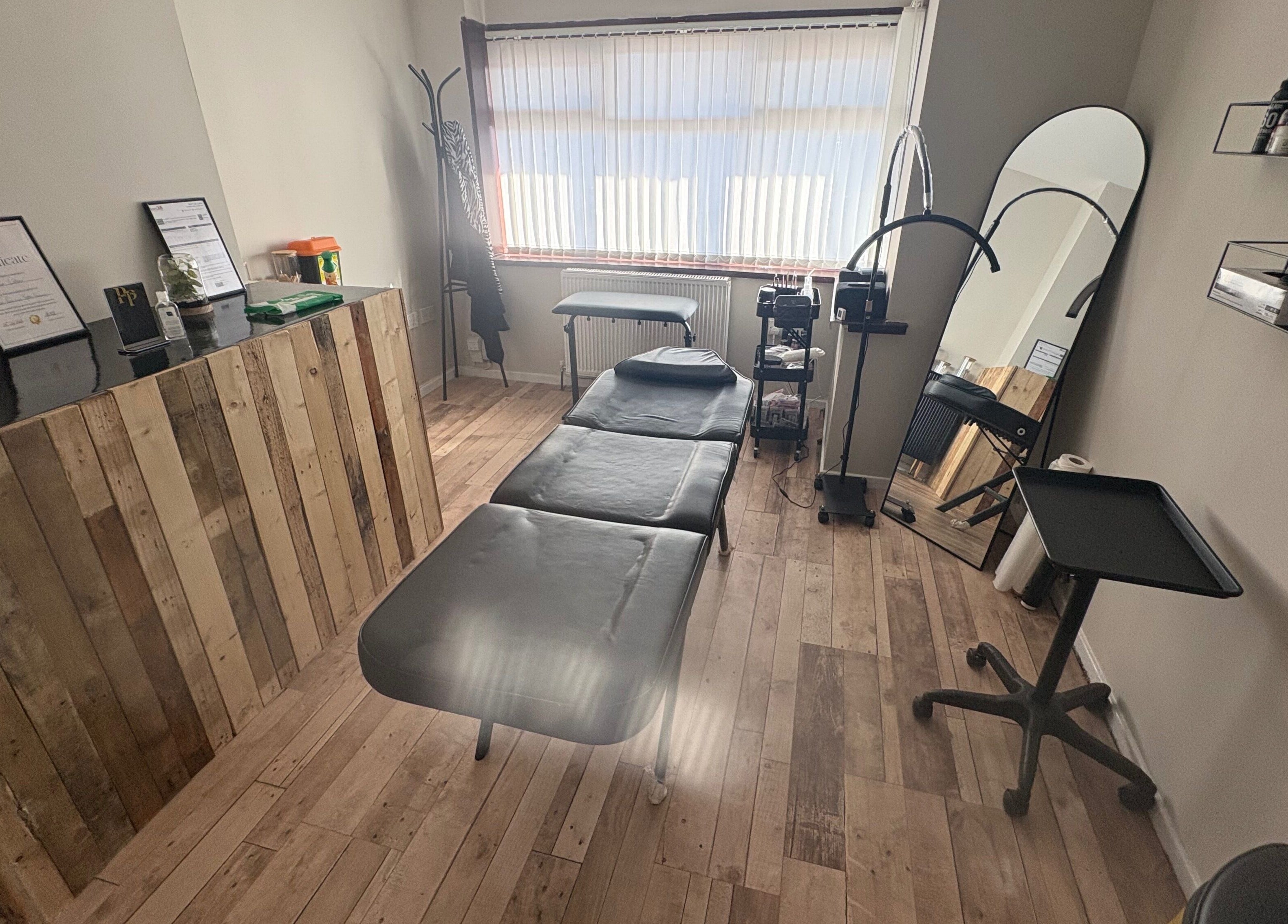 Pretty&Pain serene treatment room with bed and wooden decor in Willenhall, England, GB.