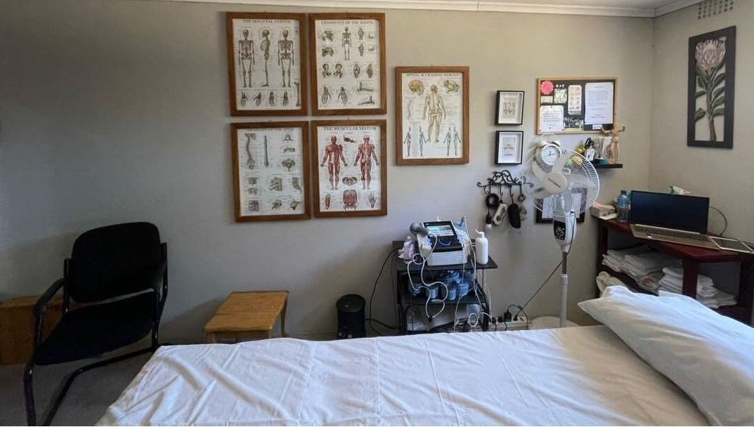 Therapeutic room at Dynamic Physical Therapy - Town Center, Lusaka, featuring anatomy charts and modern equipment.