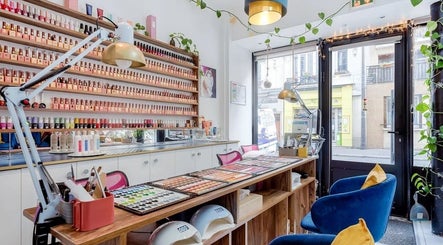 Intérieur élégant de 23 Nail Salon à Paris, Île-de-France, FR avec des étagères de vernis à ongles colorés.
