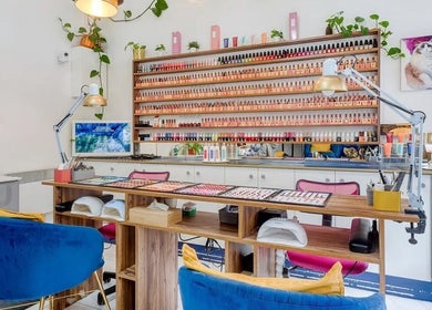 Espace intérieur élégant de 23 Nail Salon à Paris, Île-de-France, FR avec un mur de vernis attractif.