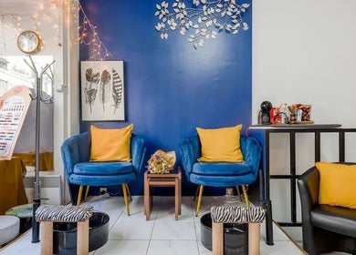 Intérieur élégant de 23 Nail Salon à Paris, Île-de-France, FR, avec fauteuils bleus et décoration murale.