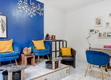 Intérieur moderne de 23 Nail Salon à Paris, Île-de-France, FR avec fauteuils bleus et décor mural.