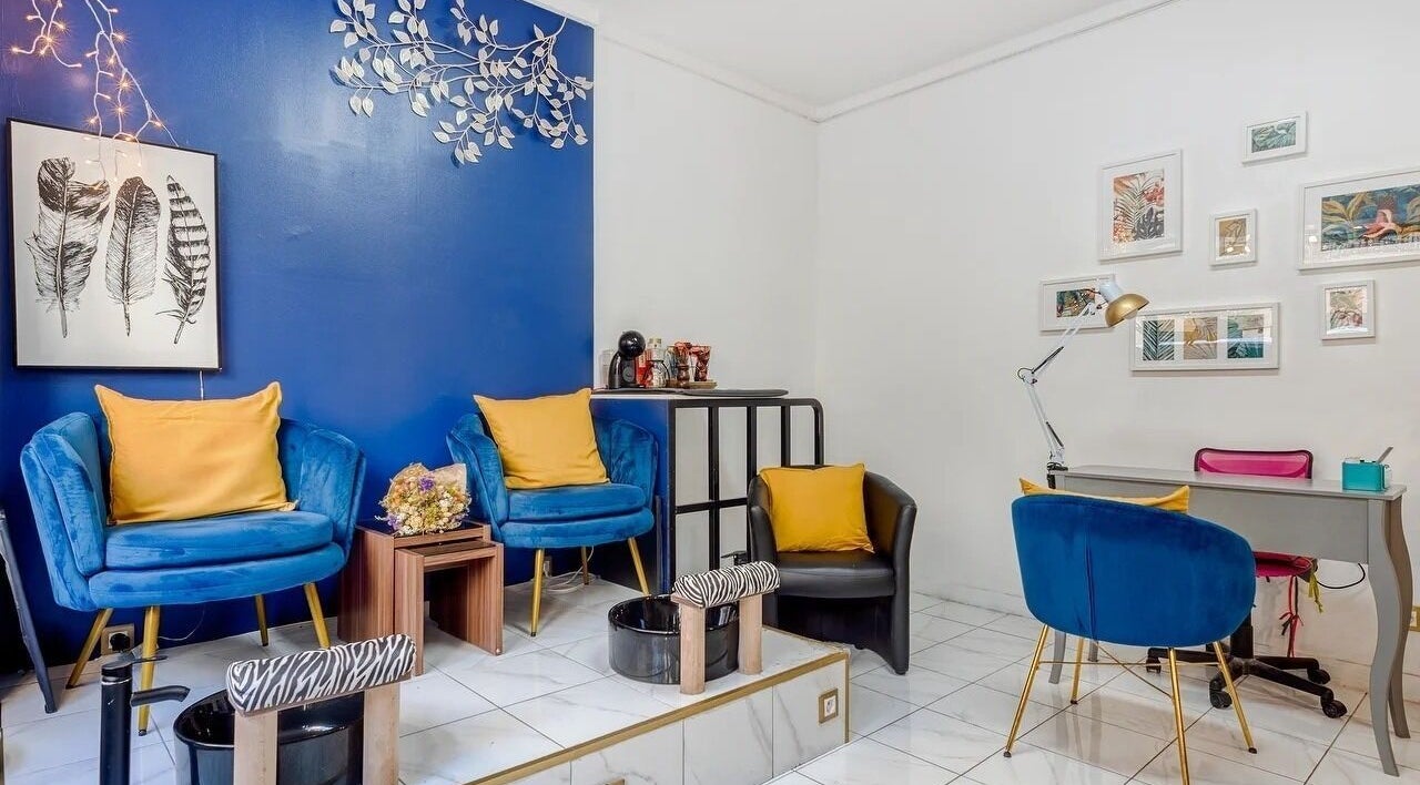 Salon chic à 23 Nail Salon, Paris, Île-de-France, FR avec fauteuils bleus et déco élégante.