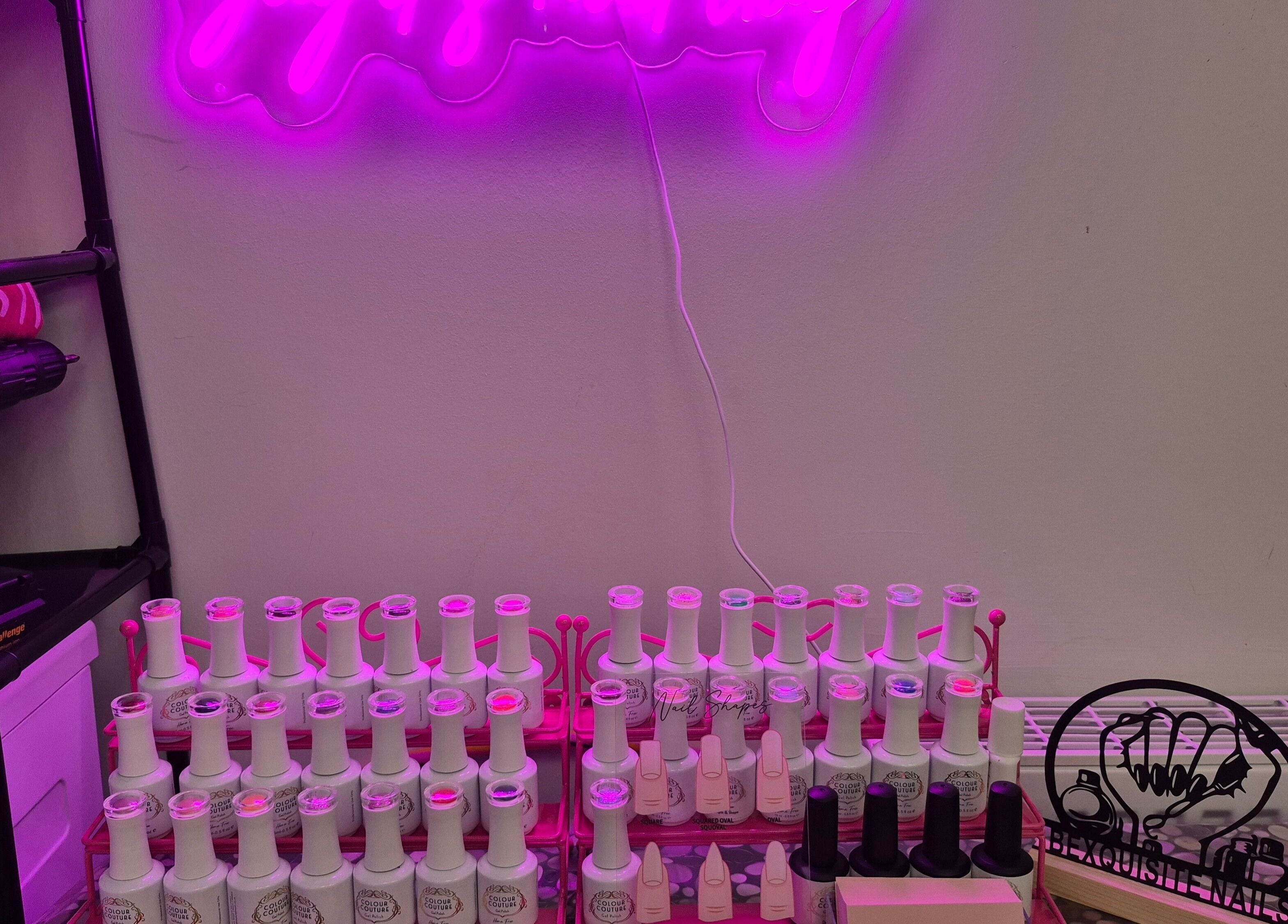 Vibrant nail polish display under pink lighting at BeXquisite Nails, Hucknall, England, GB.