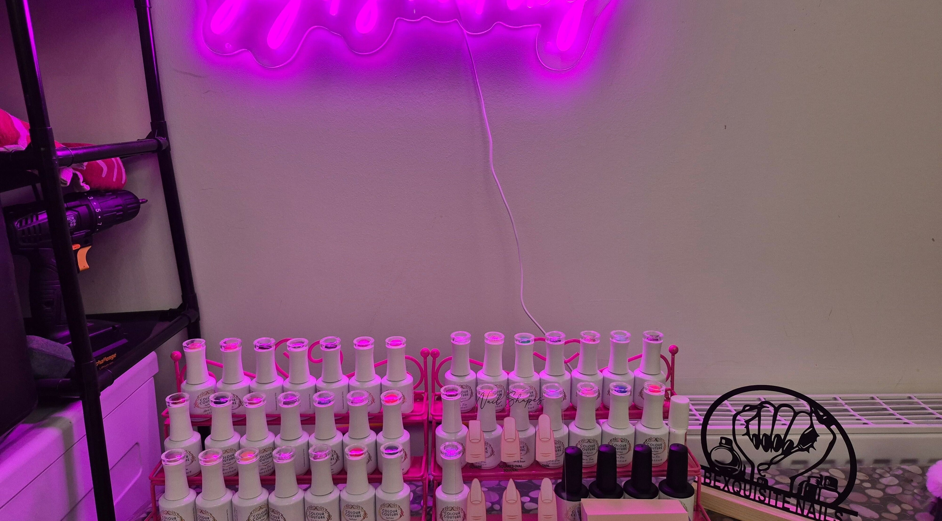 Vibrant nail polish display under pink lighting at BeXquisite Nails, Hucknall, England, GB.