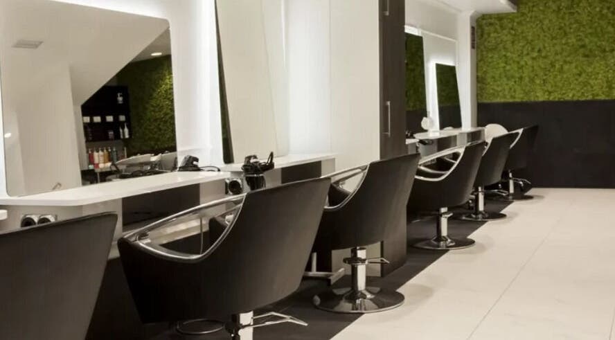 Interior moderno de Llongueras Pedro María Ric en Zaragoza, Aragón, ES, con sillas elegantes y espejos iluminados.