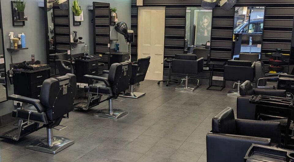 Spacious interior of Evolution Hair and Beauty Salon in London, England, GB with modern styling chairs and mirrors.