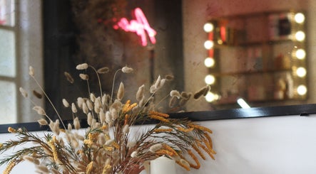 Elegant flower arrangement at Nails by Stacey, Newcastle-under-Lyme, England, GB with a lit vanity mirror.