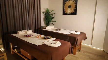 Interior elegant al Breeze Luxury Spa, București, două mese masaj cu decorațiuni relaxante.