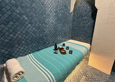 Masă de masaj elegantă la Breeze Luxury Spa, București, București, RO, cu prosoape și uleiuri aromatice.