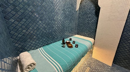 Masă de masaj elegantă la Breeze Luxury Spa, București, București, RO, cu prosoape și uleiuri aromatice.