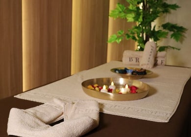 Masa de masaj pregătită la Breeze Luxury Spa, București, București, RO, cu lumânări și prosoape fine.
