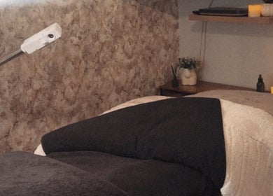 Cozy treatment room at Beauty By Alessia, Bedford, England, GB, featuring a massage table and soft lighting.