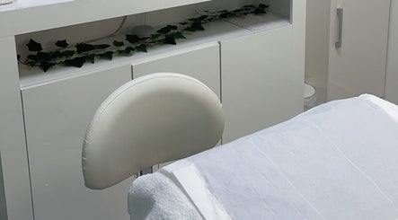 Relaxing treatment room at Classylovelash, Birmingham, England, GB with white decor and a leafy touch.