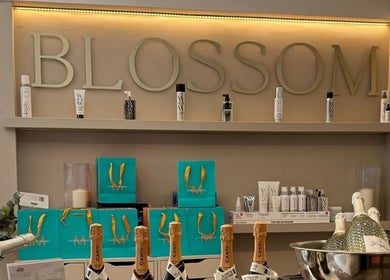 Product display at Amy Nicole, Neath, Wales, GB featuring beauty bottles with 'BLOSSOM' sign.