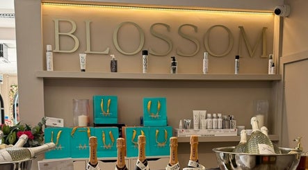 Product display at Amy Nicole, Neath, Wales, GB featuring beauty bottles with 'BLOSSOM' sign.