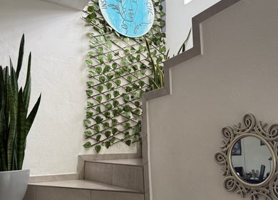 Interior del Instituto de Cosmiatría y Cosmetología J&E - Spa & Beauty en Ecatepec, MX con escalera y decoración natural.