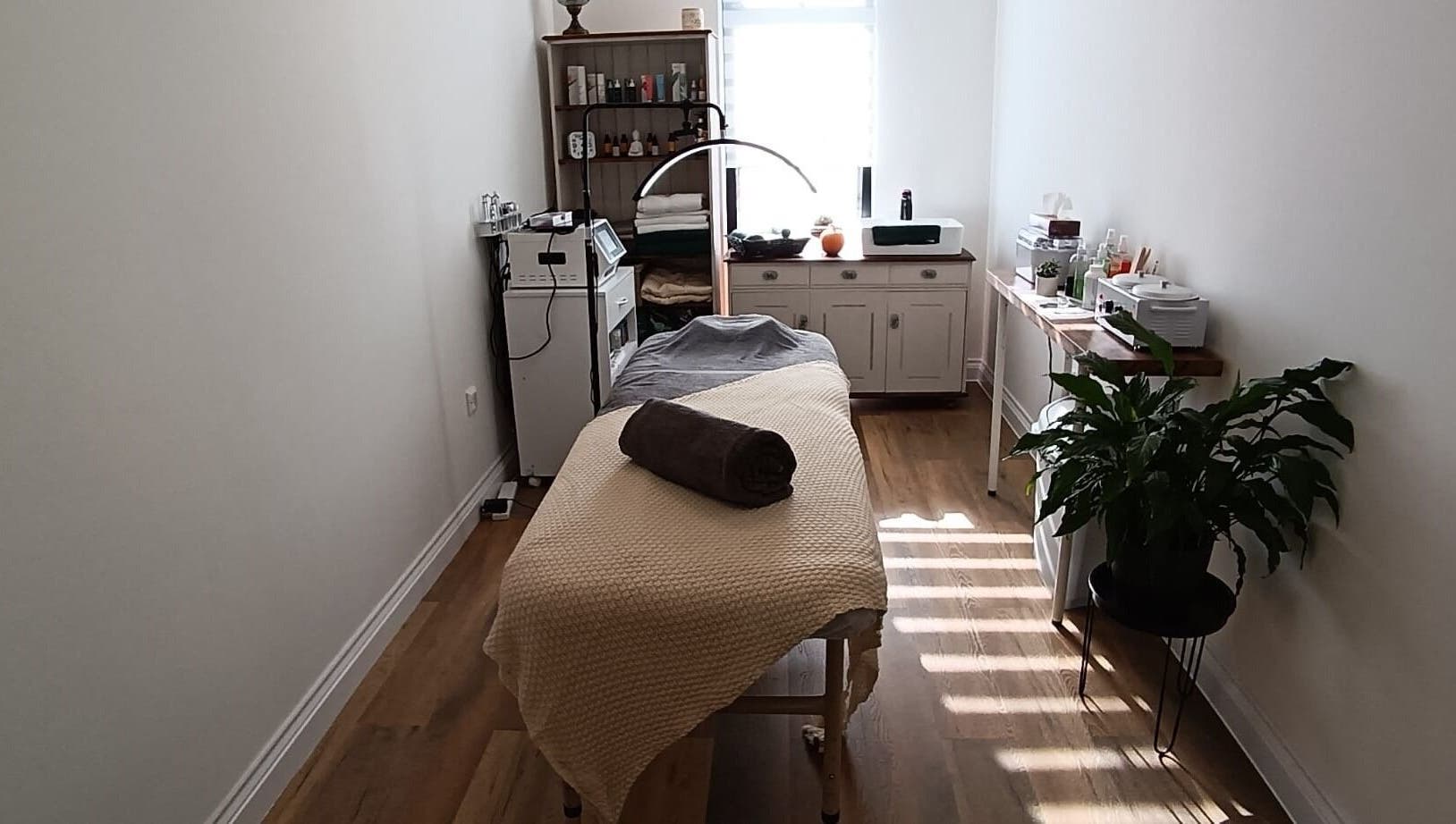 Massage room at NUDE, London, England, GB, featuring a cozy bed, modern decor, and tranquil ambiance.