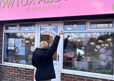 Front view of The Gloss By Milly, beauty salon in Fleetwood, England, GB, featuring a pink sign and floral decor.