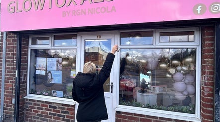 Front view of The Gloss By Milly, beauty salon in Fleetwood, England, GB, featuring a pink sign and floral decor.