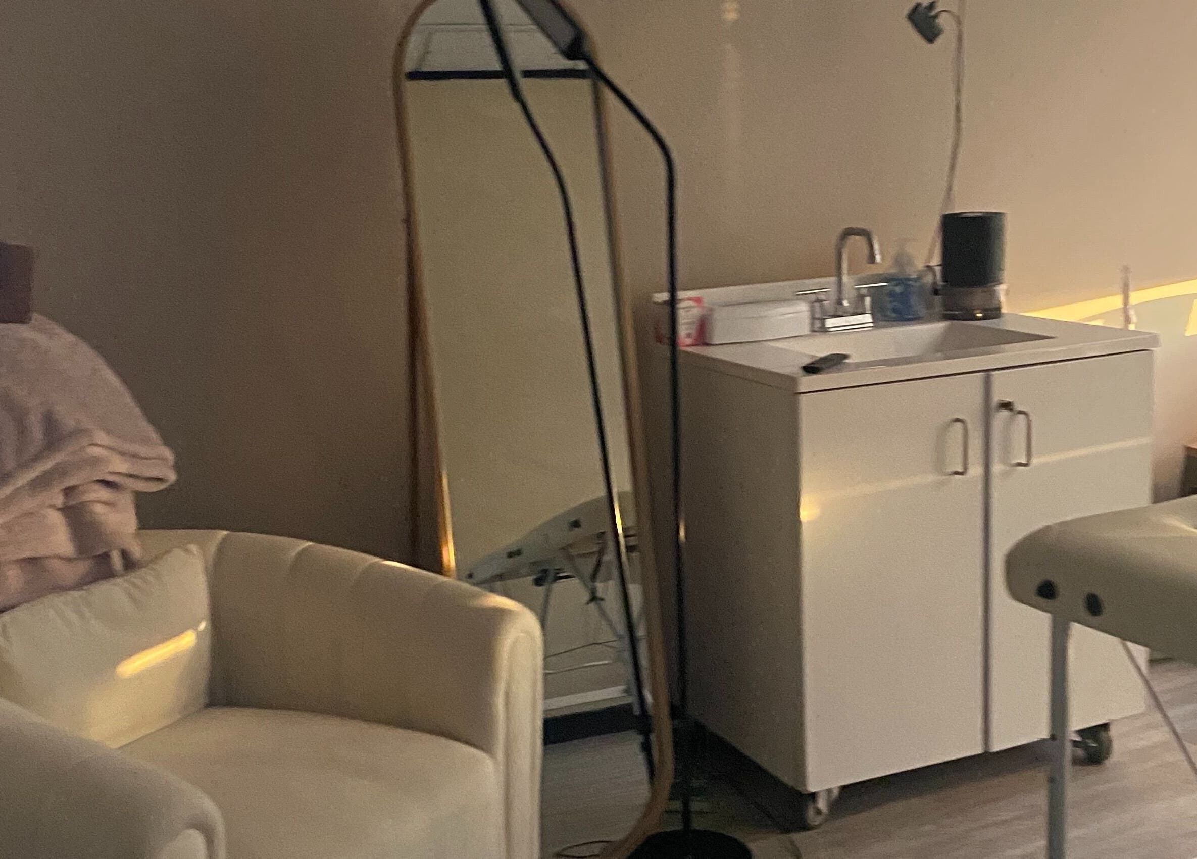 Calming spa room at Hidden Gem in Rockdale, Texas, US featuring comfortable chair and sleek mirror.