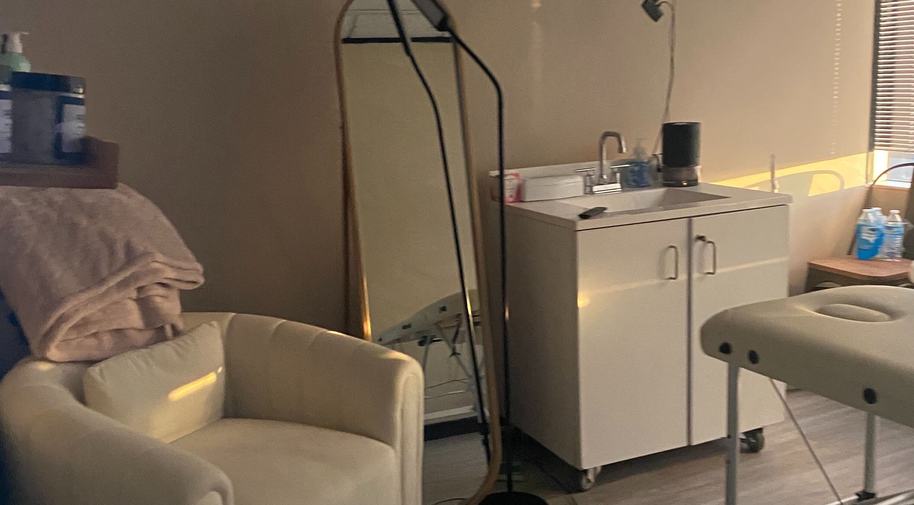 Calming spa room at Hidden Gem in Rockdale, Texas, US featuring comfortable chair and sleek mirror.