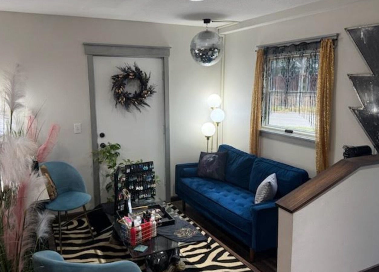 Modern lounge at Rock N Rollerz Salon, Minneapolis, Minnesota, US featuring chic decor and a cozy blue sofa.