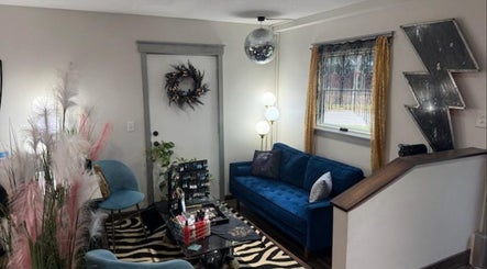 Modern lounge at Rock N Rollerz Salon, Minneapolis, Minnesota, US featuring chic decor and a cozy blue sofa.
