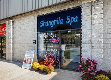 Entrance of Shangrila Head Spa in Yorktown Heights, NY with vibrant flowers and signage.