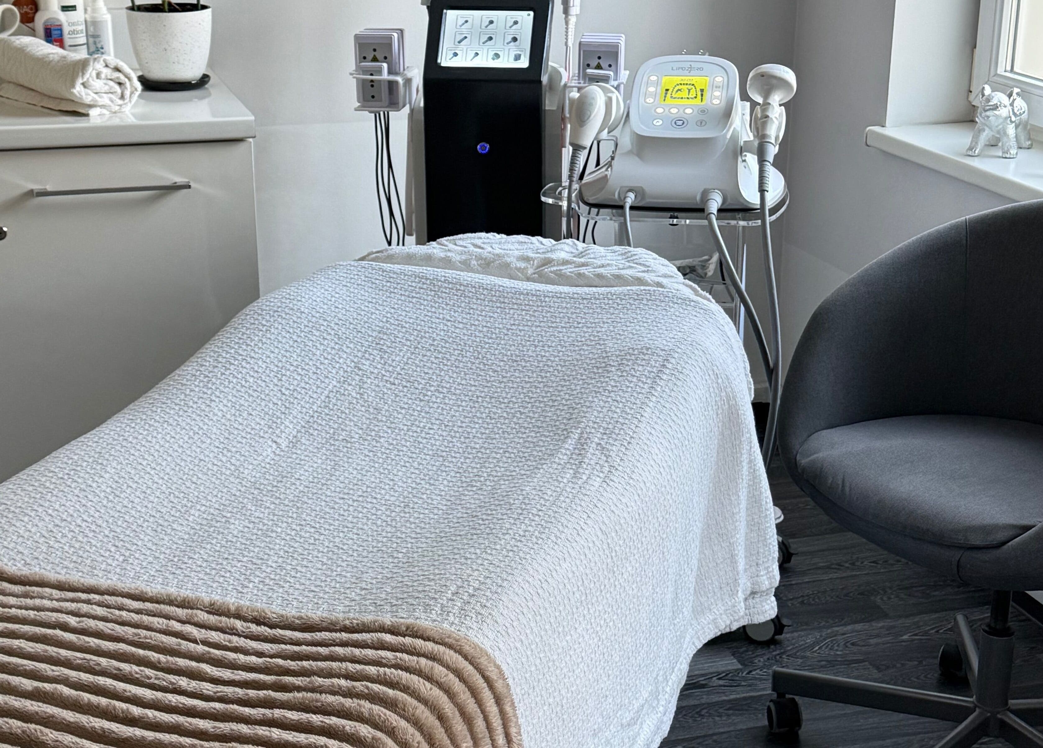 Cozy treatment room at TheLittleBirdSPA, Rīga, LV, featuring a white massage bed and modern equipment.