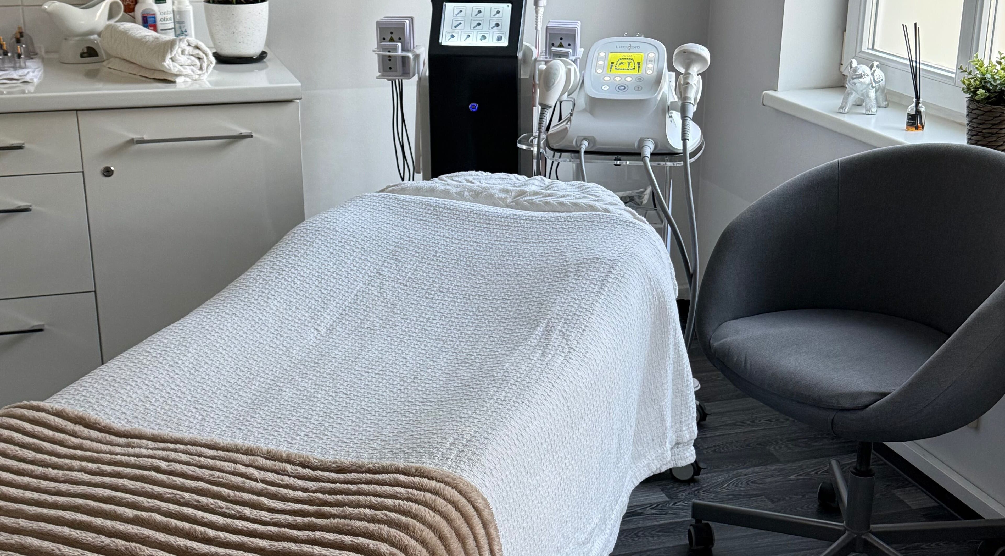 Cozy treatment room at TheLittleBirdSPA, Rīga, LV, featuring a white massage bed and modern equipment.