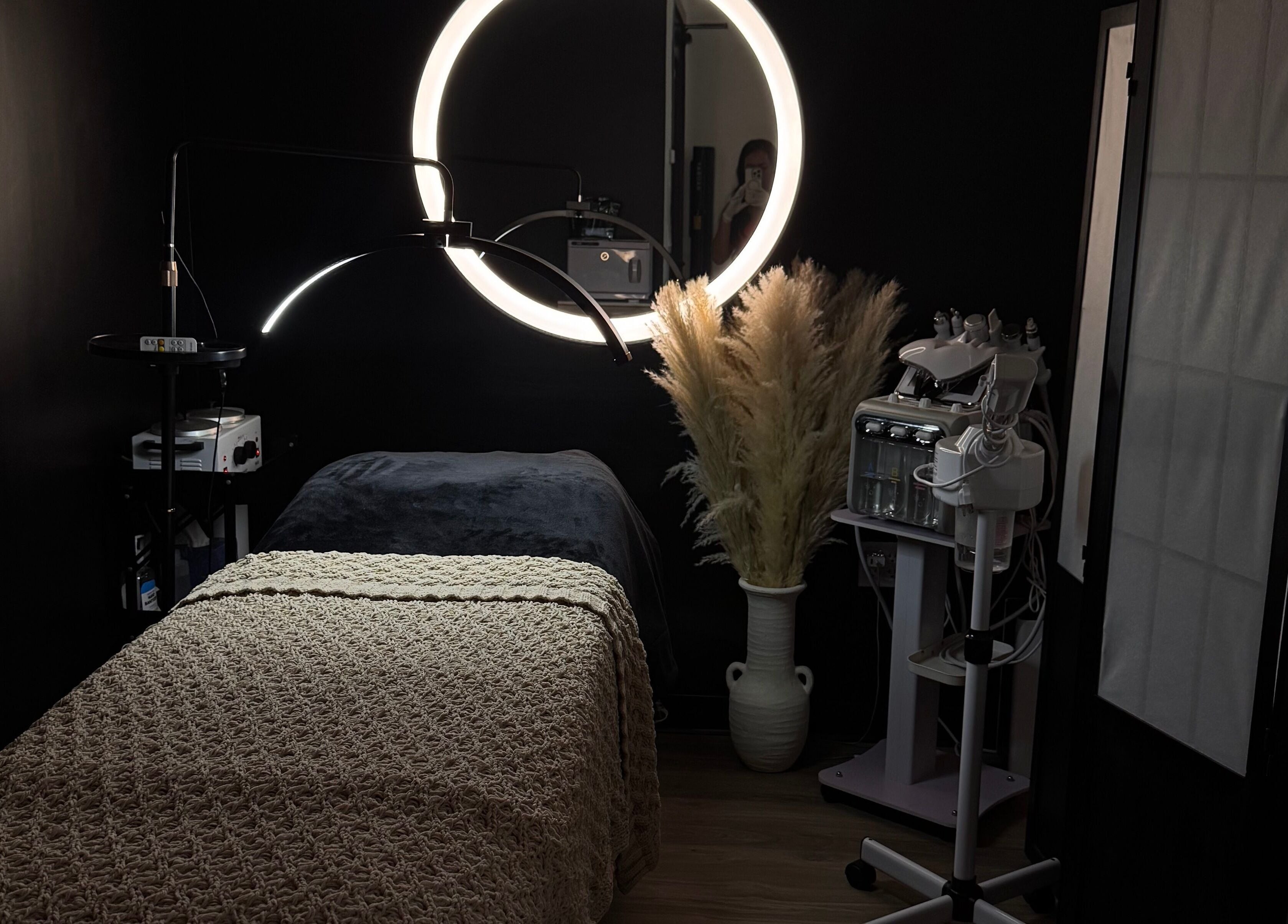 Cozy treatment room at Gloomskin Studio, Texas, Texas, US, featuring ambient lighting and wellness equipment.