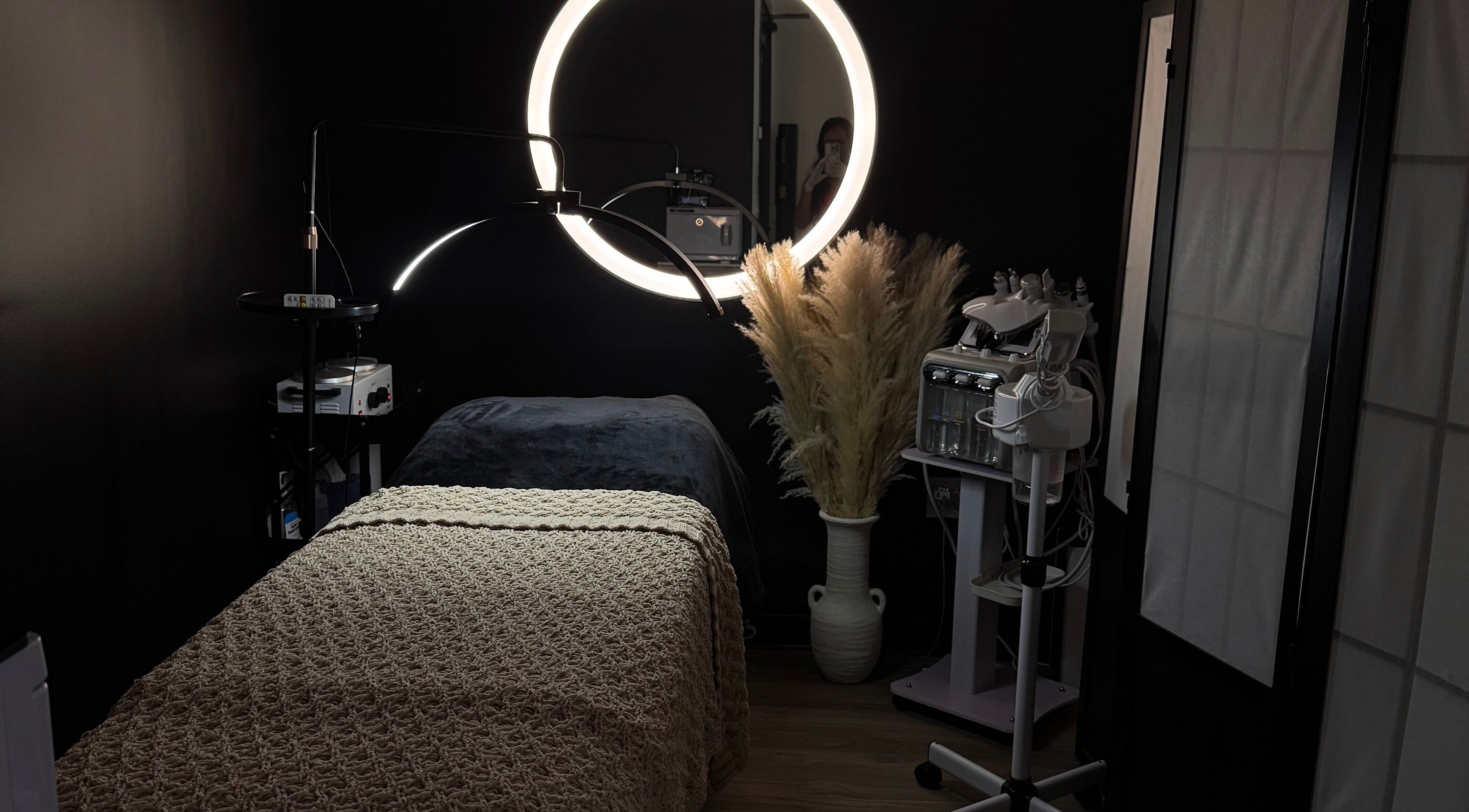 Cozy treatment room at Gloomskin Studio, Texas, Texas, US, featuring ambient lighting and wellness equipment.