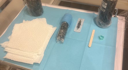 Tattoo tools at Evie’s Luxe Ink in Swindon, England, GB, arranged neatly on a blue mat.