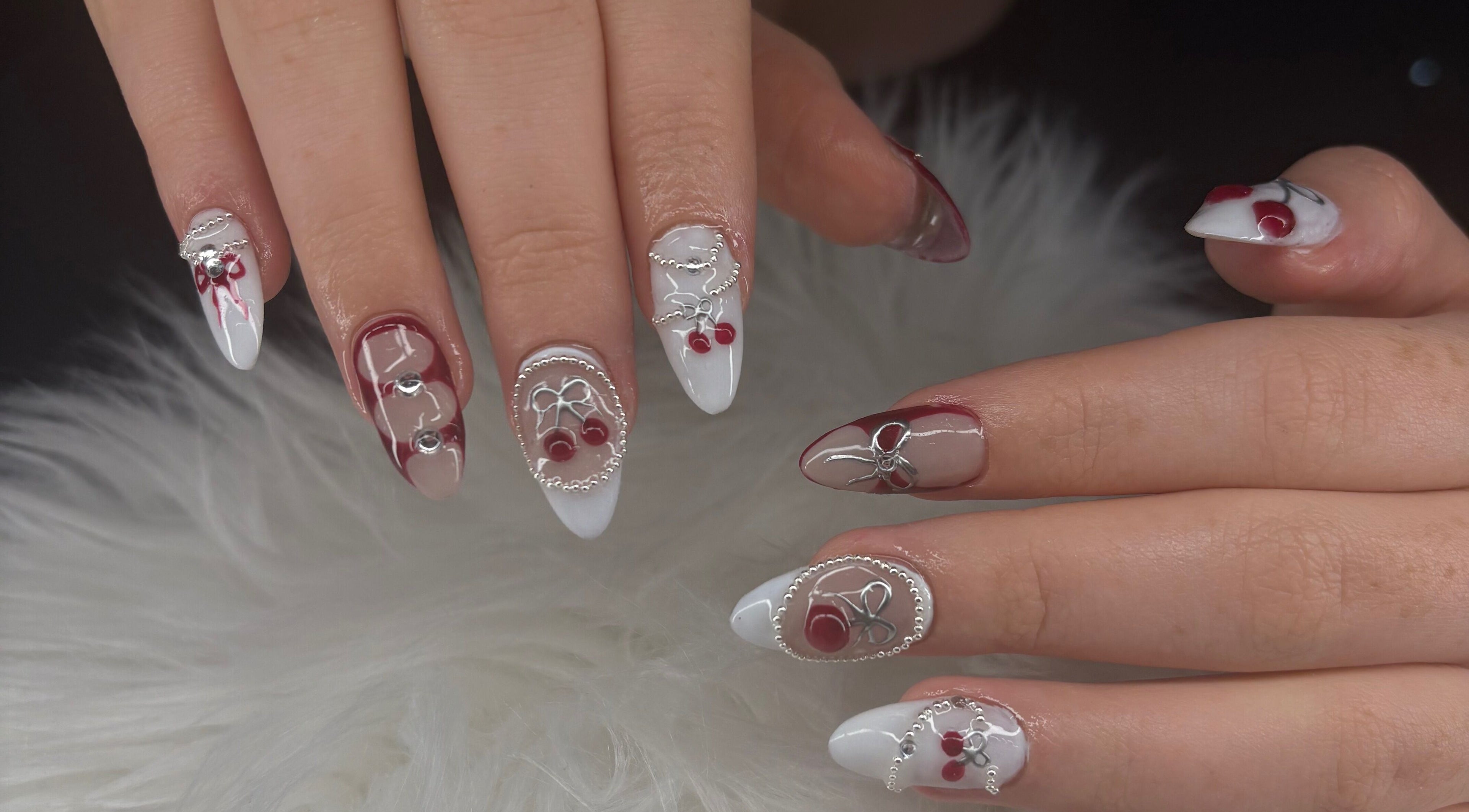 Intricate nail design at Claws By Jess, Bournemouth, England, GB, featuring red and white accents.