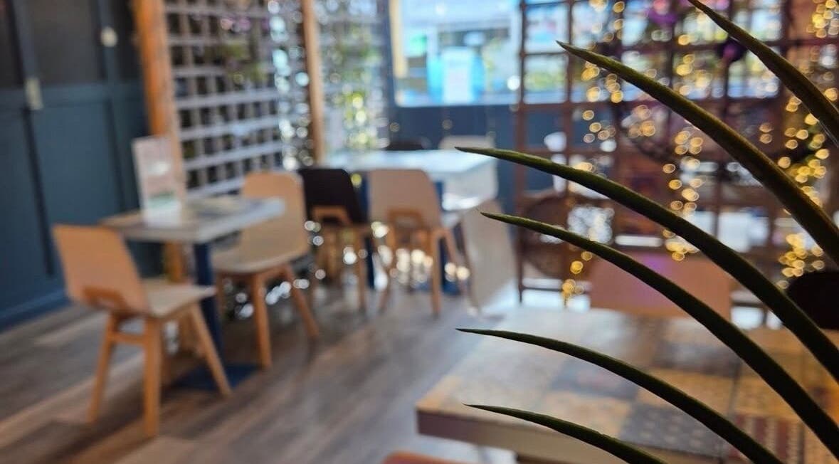 Cozy interior of Couture Lengths by Lisa, Dunmurry, Northern Ireland, GB, featuring wooden chairs and festive lights.